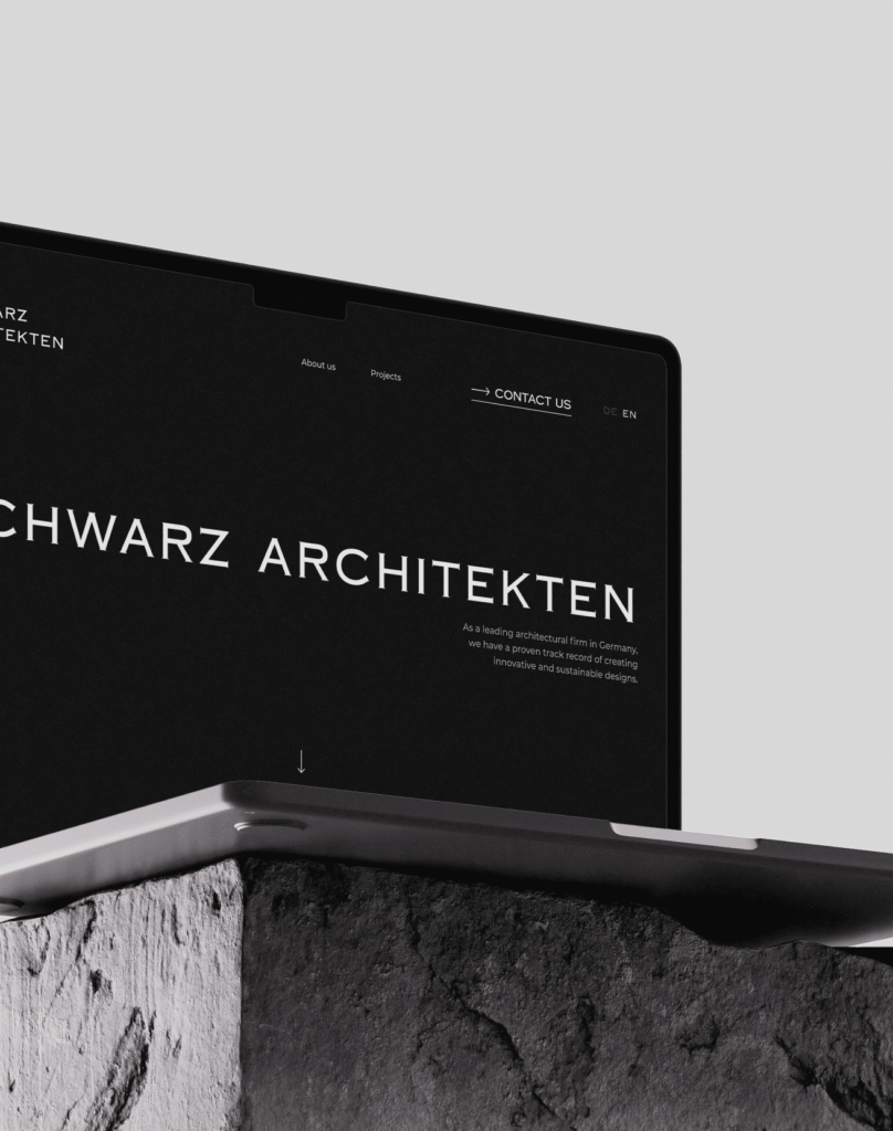 Laptop mit Webseite von Schwarz Architekten in Schwarzweiß auf steinernem Sockel